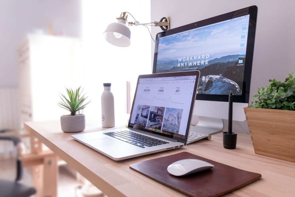 a minimalistic and clean workdesk with a laptop in front of a pc